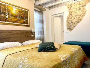 una camera da letto con un letto e un dipinto sul muro di Dimora di Charme Rooms & Apartments a Peschiera del Garda