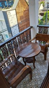 ein Holztisch und zwei Stühle auf einem Balkon in der Unterkunft Chada Mantra Hotel in Chiang Mai