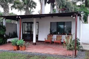 una casa con mesa, sillas y palmeras en Jardín Paraíso en Amatitlán