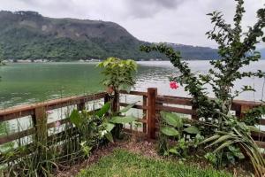 uma cerca com vista para uma massa de água em Jardín Paraíso em Amatitlán