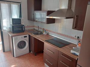 a kitchen with a washing machine and a washer at ALBORADA TRES in Burguillos