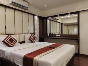 a bedroom with a large bed in a room at Hotel Shelter Palace in Navi Mumbai