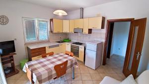 cocina pequeña con mesa, fogones y nevera en Apartments by the sea Supetar, Brac - 22673, en Supetar