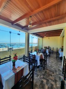 un restaurante con mesas y sillas y vistas al océano en BRISAS DE LA BAHIA HOTEL, en Paracas