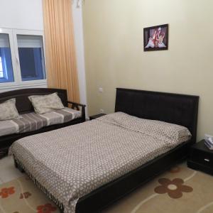 ein Schlafzimmer mit einem Bett und einem Sofa in der Unterkunft Appartement moderne, vue mer in Harqalah