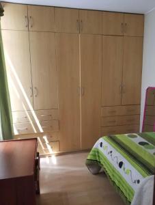 a bedroom with wooden cabinets and a bed at Alamos stay in Lima