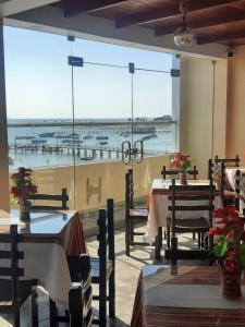 un restaurante con mesas y vistas al océano en BRISAS DE LA BAHIA HOTEL, en Paracas