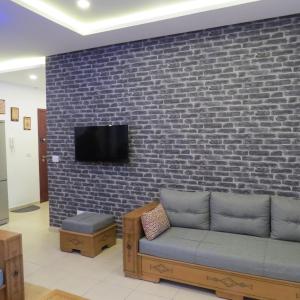 un soggiorno con divano contro un muro di mattoni di Appartement moderne, vue mer a Harqalah