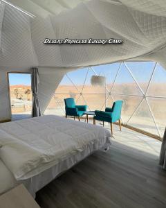 a bedroom with a bed and two blue chairs at desert princess luxury camp in Wadi Rum