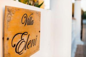 a sign that reads ollia open on a wall at Villa Eleni in Soroni