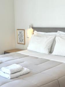 Voulis Best Global Home في أثينا: سرير ابيض كبير عليه منشفتين