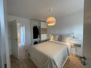 a bedroom with a large white bed and a lamp at Apartment near to Paris CDG in Aulnay-sous-Bois