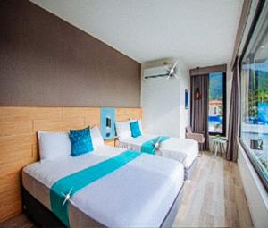a hotel room with two beds and a balcony at RedDoorz at Anton's Loft Designer Resort Pansol Calamba Laguna in Laguna