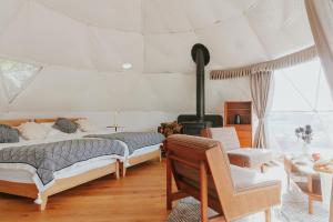 ein Schlafzimmer mit einem Bett und einem Kamin in einem Zimmer in der Unterkunft アイカフェファーム in Hokuto