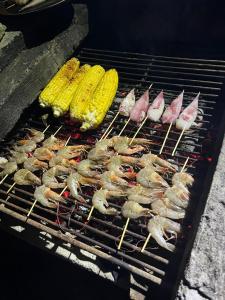 een groep garnalen en maïs op een grill bij Sayang House in Kuta Lombok