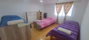 a bedroom with two beds with purple sheets at Casona Los Coihues in Tolhuin