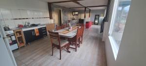 a kitchen with a table and chairs in a room at Casona Los Coihues in Tolhuin