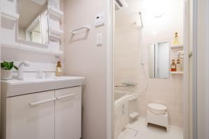 a white bathroom with a shower and a toilet at MINI HOUSE Tokyo South in Tokyo