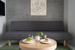 a coffee table with two plates of food on a couch at MINI HOUSE Tokyo South in Tokyo