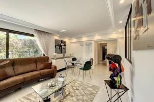 a living room with a couch and a table at 3-room apartment in a high-end residence with swimming pool in Cannes