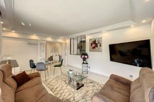 a living room with a couch and a table at 3-room apartment in a high-end residence with swimming pool in Cannes