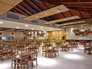 a dining room with wooden tables and chairs at Ondas Praia Resort in Porto Seguro