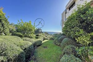 un jardín con arbustos junto a un edificio en Superb studio with terrace in a high-end residence with swimming pool, en Cannes