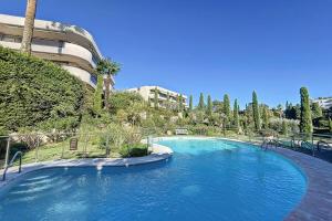 una gran piscina azul frente a un edificio en Superb studio with terrace in a high-end residence with swimming pool, en Cannes