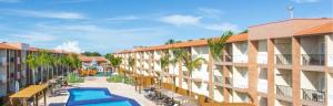 an apartment complex with a swimming pool and benches at Ondas Praia Resort in Porto Seguro