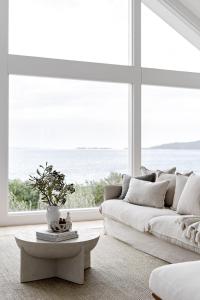 a living room with a white couch and a large window at Salt at Shoal Bay in Shoal Bay