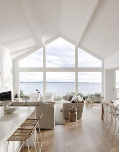 a white living room with a view of the ocean at Salt at Shoal Bay in Shoal Bay