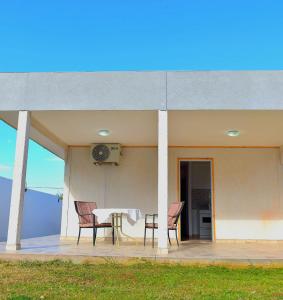 a patio with two chairs and a table and a clock at Cabañas La Soñada in Chilecito