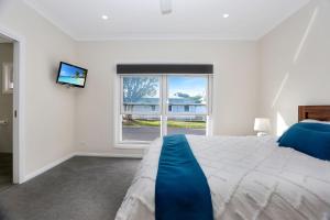 ein Schlafzimmer mit einem großen Bett und einem Fenster in der Unterkunft Wataview Marine Drive in Tea Gardens