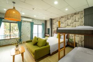 - une chambre avec un lit et un canapé vert dans l'établissement Benzen Boutique Stays, à Đà Nẵng