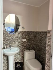 W łazience znajduje się umywalka, toaleta i lustro. w obiekcie HOSTAL SANTA ISABEL-JAUJA w Jauja
