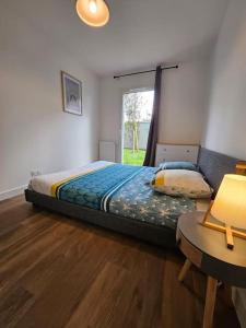 a bedroom with a bed and a table and a window at Appartement élégant et bien situé in Biscarrosse