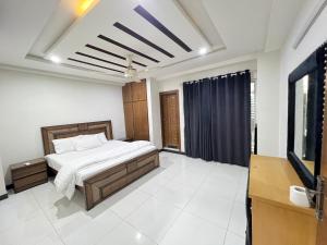 a bedroom with a bed and a television in it at Luxury Apartment Hotel in Islamabad