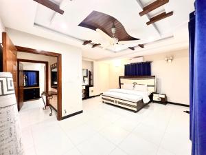 a bedroom with a bed and a ceiling fan at Luxury Apartment Hotel in Islamabad