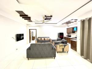 ein Wohnzimmer mit Sofas und einem TV in der Unterkunft Luxury Apartment Hotel in Islamabad
