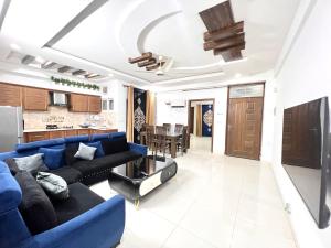 a living room with a blue couch and a kitchen at Luxury Apartment Hotel in Islamabad