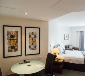 a hotel room with a bed and a desk and a table at Darling Harbour Apartments in Sydney