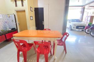 a table and four red chairs in a room at Aisyah Homestay Syariah RedPartner in Stabat