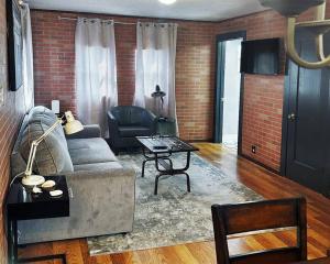 uma sala de estar com um sofá e uma mesa em Neptune's Cottage em Galveston
