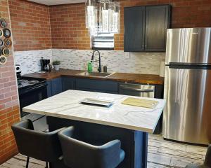 uma cozinha com uma mesa com cadeiras e um frigorífico em Neptune's Cottage em Galveston