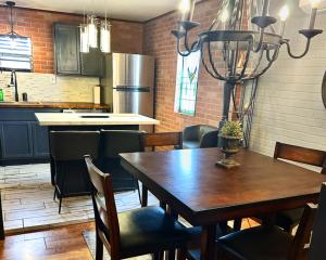 eine Küche mit einem Holztisch und Stühlen sowie eine Küche mit einem Kühlschrank in der Unterkunft Neptune's Cottage in Galveston