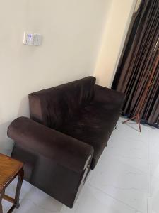 a brown leather couch in a room with a table at Murree Oaks Tulip Block in Murree