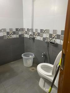 a bathroom with a toilet and a bucket at Murree Oaks Tulip Block in Murree