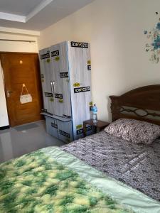 - une chambre avec un lit à côté d'un réfrigérateur dans l'établissement Murree Oaks Tulip Block, à Murree