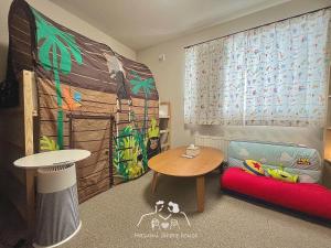 a childs room with a table and a table and a couch at 札幌駅地下鉄15分直通/駐車無料/南向新築戸建/最大3名/車で最寄り駅お迎え可能/北海道大学バス直通 in Sapporo