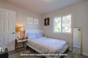 een slaapkamer met een bed en een raam bij Entire Spacious 4-Bedroom House w Free Pool Access, Garage & Parking in Prime Location in San Diego
